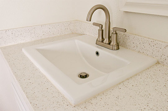 A white quartz counter in a bathroom